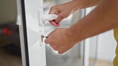 Evdeki anahtarı kullanarak kapıyı kapatan genç bir İspanyol.