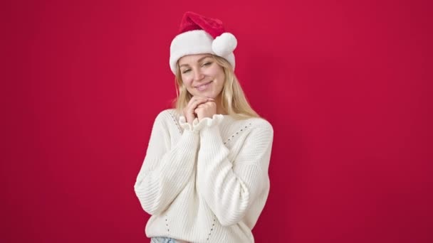 Giovane Donna Bionda Sorridente Fiducioso Indossa Cappello Natale Sfondo Rosso — Video Stock