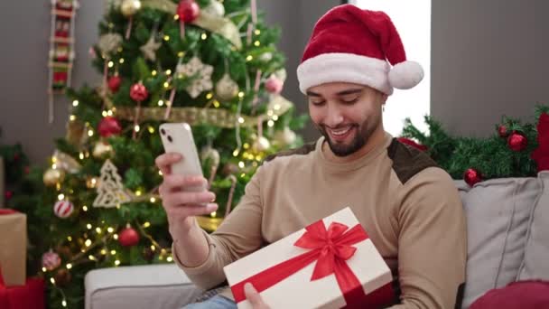 Junger Araber Mit Smartphone Und Geschenk Weihnachtsbaum Hause — Stockvideo
