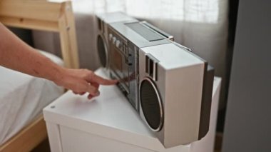 Genç İspanyol adam yatak odasında müzik setini açıyor.