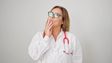 Orta yaşlı İspanyol kadın doktor şüpheli bir ifadeyle izole edilmiş beyaz arka plan üzerinde düşünüyor.
