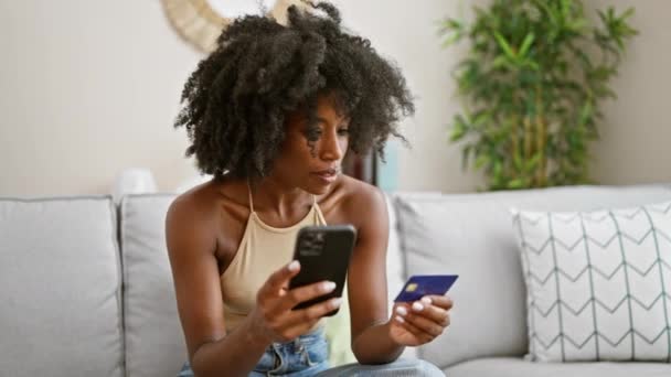 Mujer Afroamericana Compras Con Teléfono Inteligente Tarjeta Crédito Sentado Sofá — Vídeo de stock
