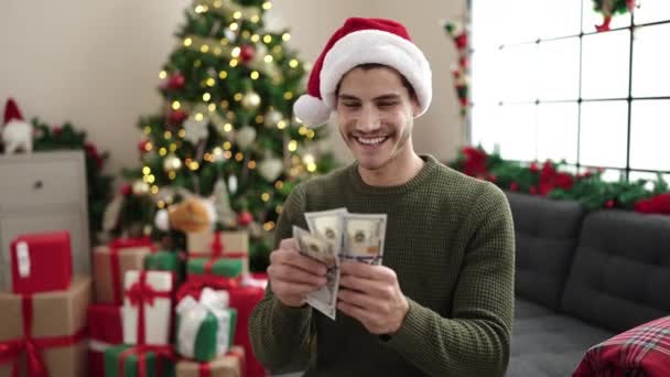 Jovem Hispânico Contando Dólares Sentado Sofá Pela Árvore Natal Casa — Vídeo de Stock