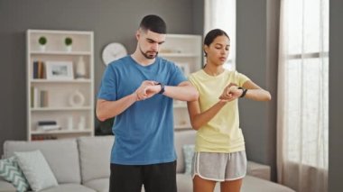 Güzel bir çift, evde birlikte sağlık yolculuklarına başlarken, saat ilerlerken değişmez bir konsantrasyonla antrenman yapıyorlar.