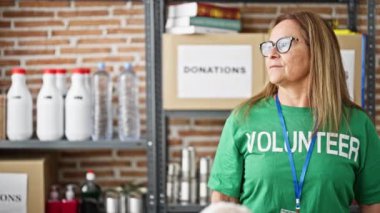 Orta yaşlı İspanyol kadın gönüllü yardım merkezinde ciddi bir yüzle duruyor.