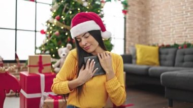 Genç, güzel, İspanyol bir kadın Noel 'i kutluyor. Evde fotoğrafçılığa bakıyor.
