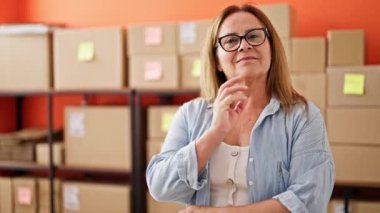 Orta yaşlı İspanyol bir kadın. İş adamı. Ofiste kendine güvenen bir şekilde gülümsüyor.