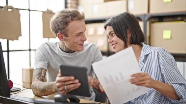 İki ekomünikasyon işçisi ofiste touchpad okuma belgesi kullanıyor.