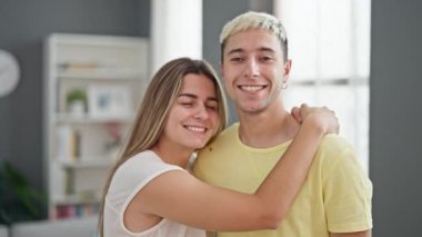 Güzel çift gülümsüyor. Kendilerine güveniyorlar. Evde öpüşüyorlar.