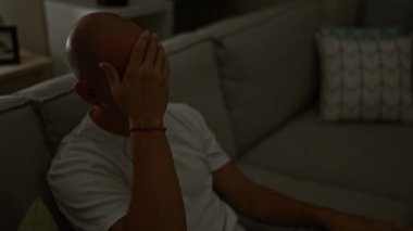 Genç İspanyol adam evde kulaklık takarak kanepede otururken strese girdi.