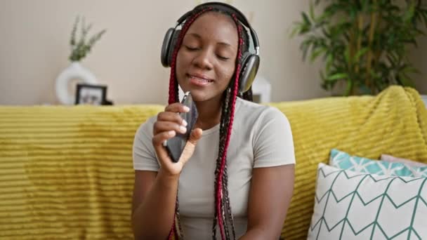 Mujer Afroamericana Confiada Cantando Alegremente Corazón Relajándose Sofá Casa Mientras — Vídeos de Stock