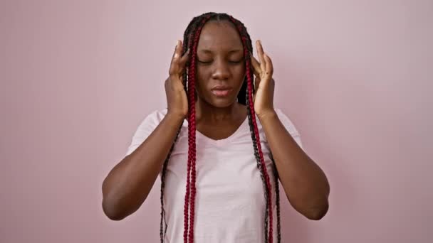 忧心忡忡的非洲裔美国女人 被生活的挣扎压垮了 独自站在孤独的粉色背景上 忧郁的表情揭示出严重的头痛和精神压力 — 图库视频影像