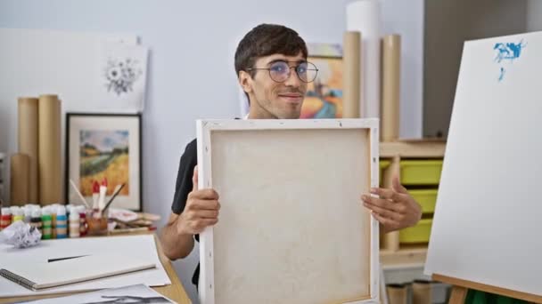 Sonriente Confiado Joven Hispano Dibuja Apasionadamente Estudio Arte Retrato Artista — Vídeo de stock