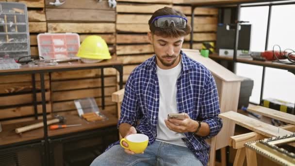 Guapo Joven Árabe Carpintero Profesión Saboreando Café Mientras Escribe Smartphone — Vídeos de Stock