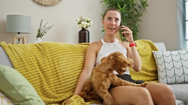 Junge Kaukasierin Mit Hund Spielt Auf Dem Sofa Und Telefoniert — Stockvideo