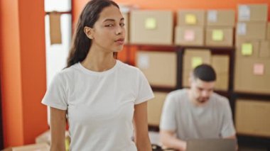 İki kendine güvenen işçi, bir erkek ve bir kadın, bir iş projesinde neşeyle takım oluyorlar, bir e-ticaret ofisinde bilgisayar kaosunun ortasında gülüyorlar..