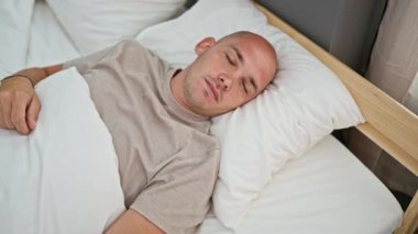 Genç İspanyol adam yatakta uzanıp yatak odasında uyuyor.