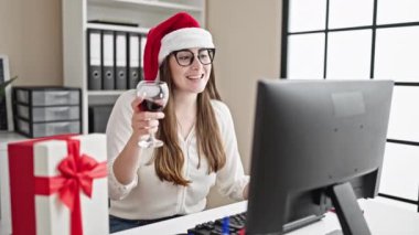 Genç ve güzel İspanyol iş kadını Noel 'i kutluyor. Ofiste şarapla kadeh kaldırıyor.