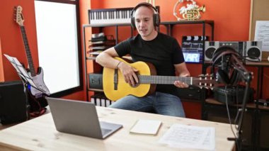 Genç İspanyol müzisyen müzik stüdyosunda online klasik gitar dersi alıyor.