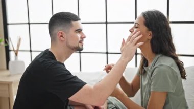 Güzel bir çift yatakta dinleniyor. Sıcak yatak odalarında sevgi ve özenle cilt kremi sürüyorlar.