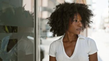 Sokakta ciddi bir ifadeyle duran Afrikalı Amerikalı kadın.