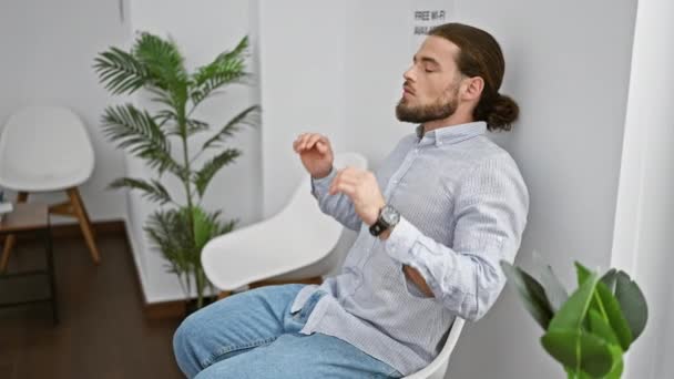 Jovem Hispânico Sentado Cadeira Esticando Braços Estressado Sala Espera — Vídeo de Stock
