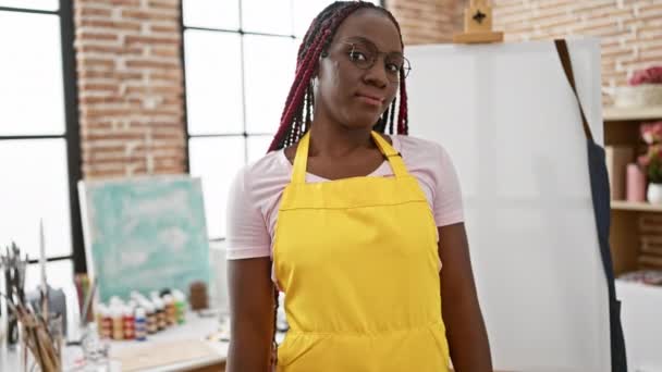 アフリカ系アメリカ人アーティストは明るい笑顔で 彼女のアートスタジオに立って 絵筆を手に 腕を交差させた — ストック動画