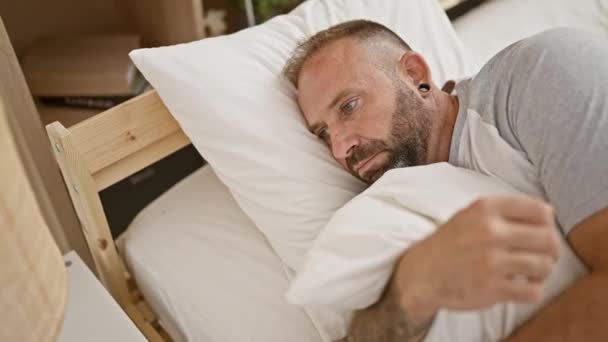 Yakışıklı Genç Adam Rahat Bir Yatakta Uzanıyor Ciddi Bir Yüz — Stok video