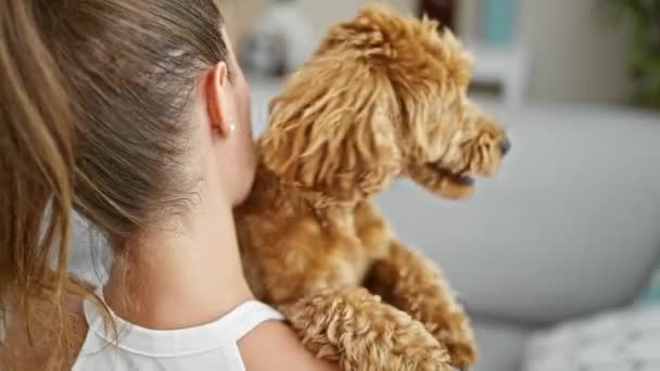 自宅で後ろに抱きしめる犬を持つ若い白人女性 — ストック動画