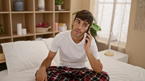 Aufgebrachter Junger Hispanischer Mann Tief Ernsthaften Telefongesprächen Sitzt Unbequem Schlafzimmer — Stockvideo