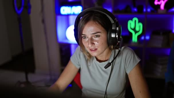 金发姑娘在游戏室里玩电子游戏 给人一种胜利的感觉 流露出自信和快乐 — 图库视频影像