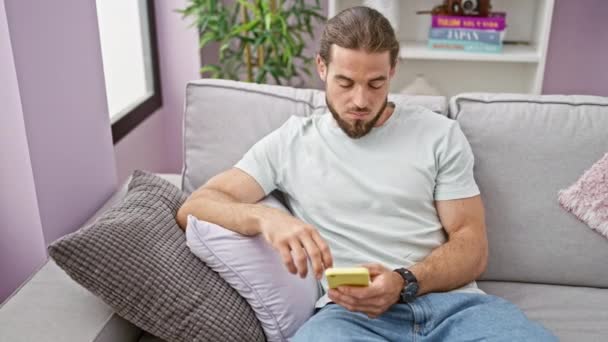 Joven Hombre Hispano Usando Smartphone Sentado Sofá Sufriendo Dolor Cervical — Vídeos de Stock