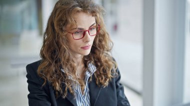 Masada oturan genç bir iş kadını pencereyi ofise doğru fırlatıyor.