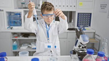 Laboratuvarda çalışan sevimli sarışın bilim adamı. Sıvıyı pipetle test tüpünde ölçüyor. Gelecekteki tıbbi araştırmalara eğlenceli bir bakış..