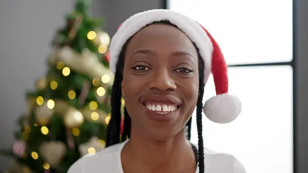 African american woman smiling confident standing by christmas tree at home
