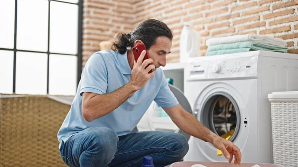 Çamaşır Odasında Çamaşır Yıkayan Orta Yaşlı Bir Adam Akıllı Telefondan — Stok fotoğraf