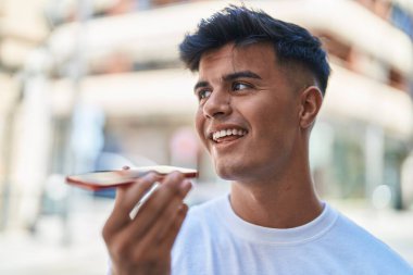 Genç İspanyol adam gülümsüyor. Kendine güveniyor. Sokakta akıllı telefondan konuşuyor.
