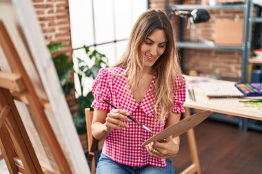 Young woman artist smiling confident drawing at art studio