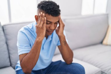 Evdeki kanepede oturan genç latin adam strese girdi.