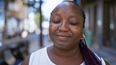 African american woman breathing with closed eyes at street