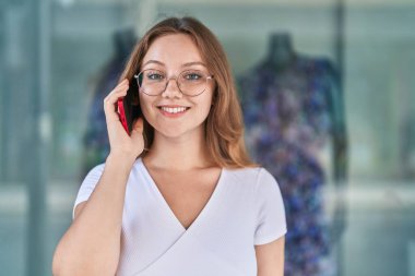 Genç sarışın kadın gülümsüyor. Kendine güveni tam. Akıllı telefondan konuşuyor.