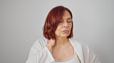 Rahim ağzı ağrısı çeken orta yaşlı bir kadın izole edilmiş beyaz arka planda duruyor.