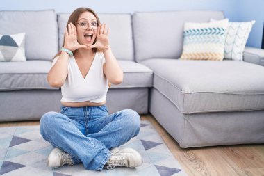 Genç, beyaz bir kadın oturma odasında yerde oturuyor. Gülümsüyor, gülümsüyor ve elleriyle dikizliyordu. Şaşırdım ve çıktım. 