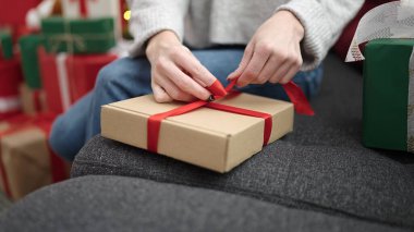 Genç sarışın kadın evde Noel hediyesi hazırlıyor.