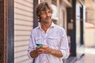 Young man using smartphone at street