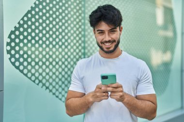 Sokakta akıllı telefon kullanan, kendine güvenen genç bir İspanyol.