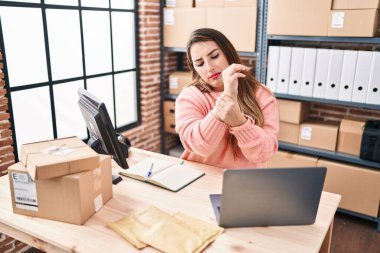 Young beautiful hispanic woman ecommerce business worker suffering for wrist pain at office