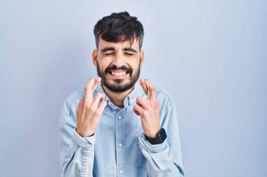 Mavi arka planda dikilen sakallı genç İspanyol adam umut ve gözleriyle gülümseyerek bana işaret etti. Şans ve batıl inançlar. 