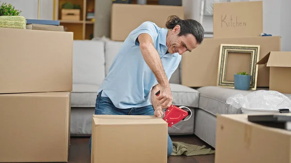 Middle age man packing cardboard box at new home