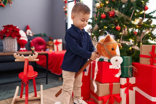 Adorable Hispanic Boy Playing Horse Toy Standing Christmas Tree Home — Stock Photo, Image